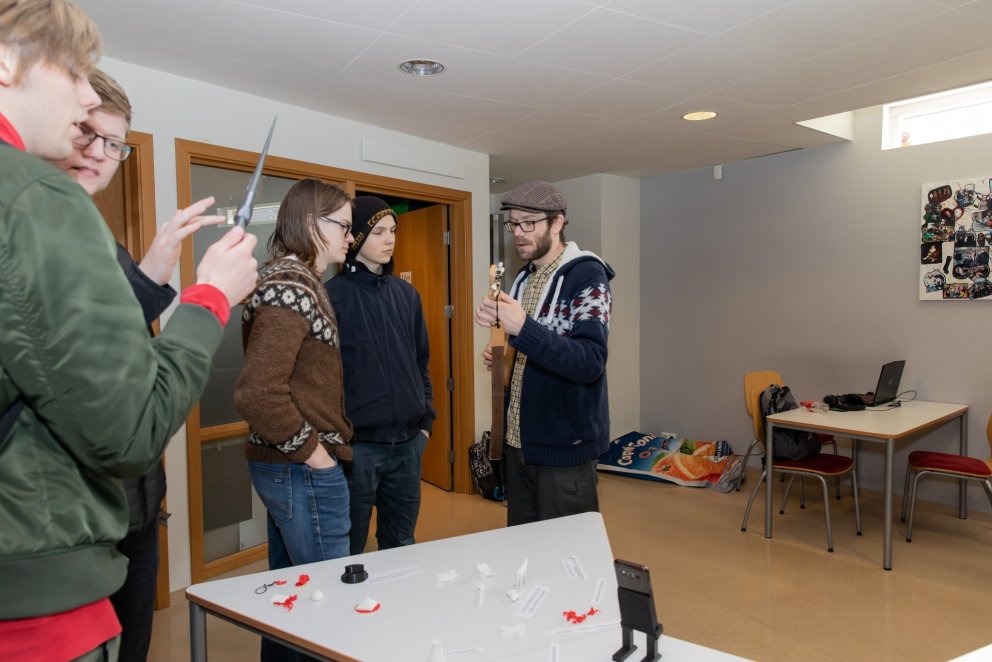 Loftur Árni Björgvinsson kennari er hér að spila fyrir gesti á gítar sem var smíðaður í skólanum.